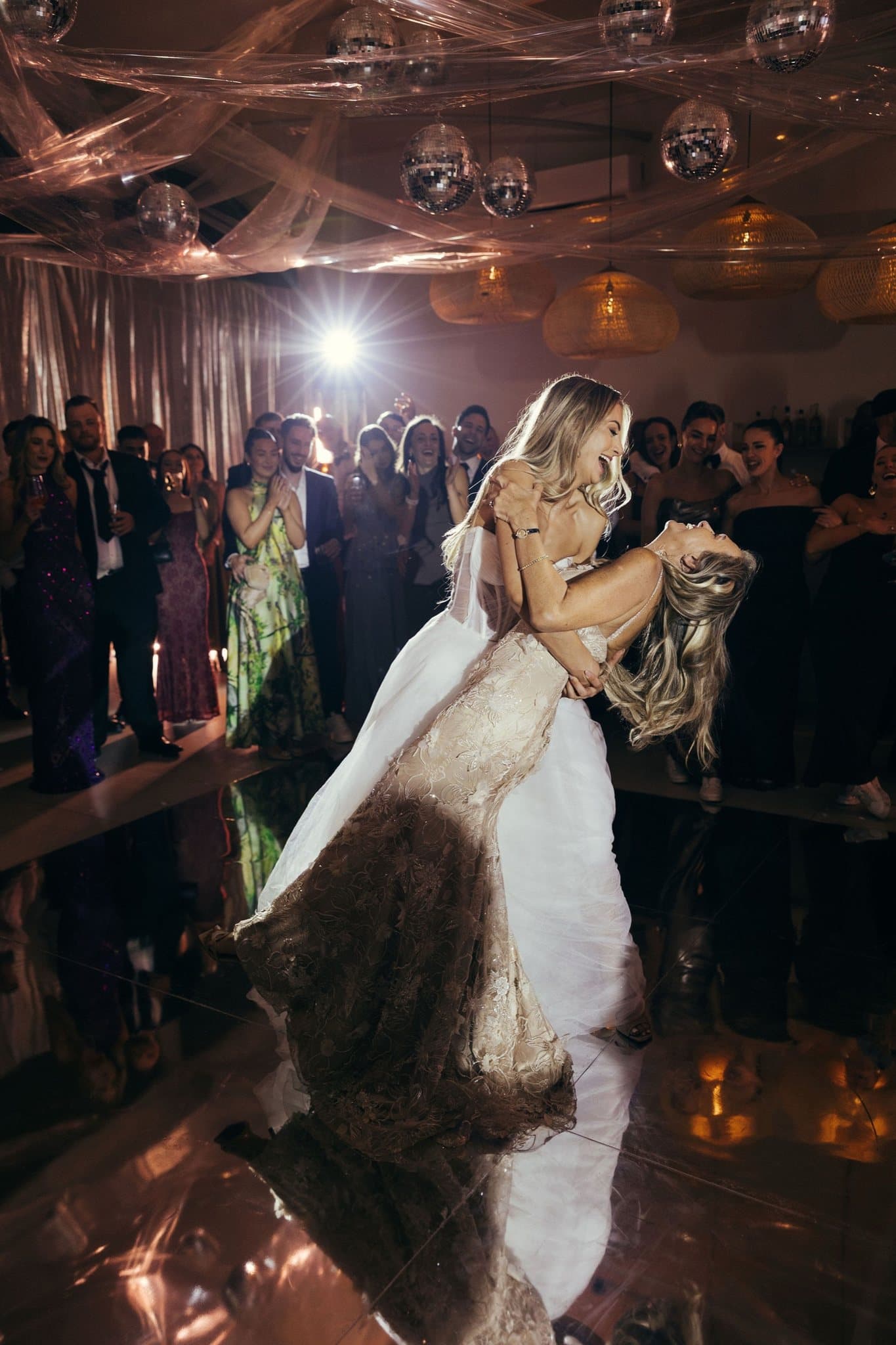 A first dance under a ceiling of mirror balls at dusk